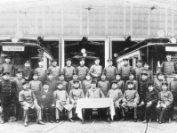 Belegschaft der Betriebs- und Fahrdienstleitung posierend vor der Wagenhalle, im Hintergrund Straßenbahnen, 1908