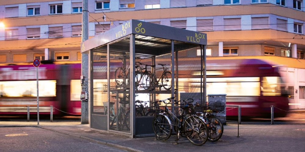 Fahrrad-Abstellanlage vor dem Hauptbahnhof mit fahrender Saarbahn im Hintergrund